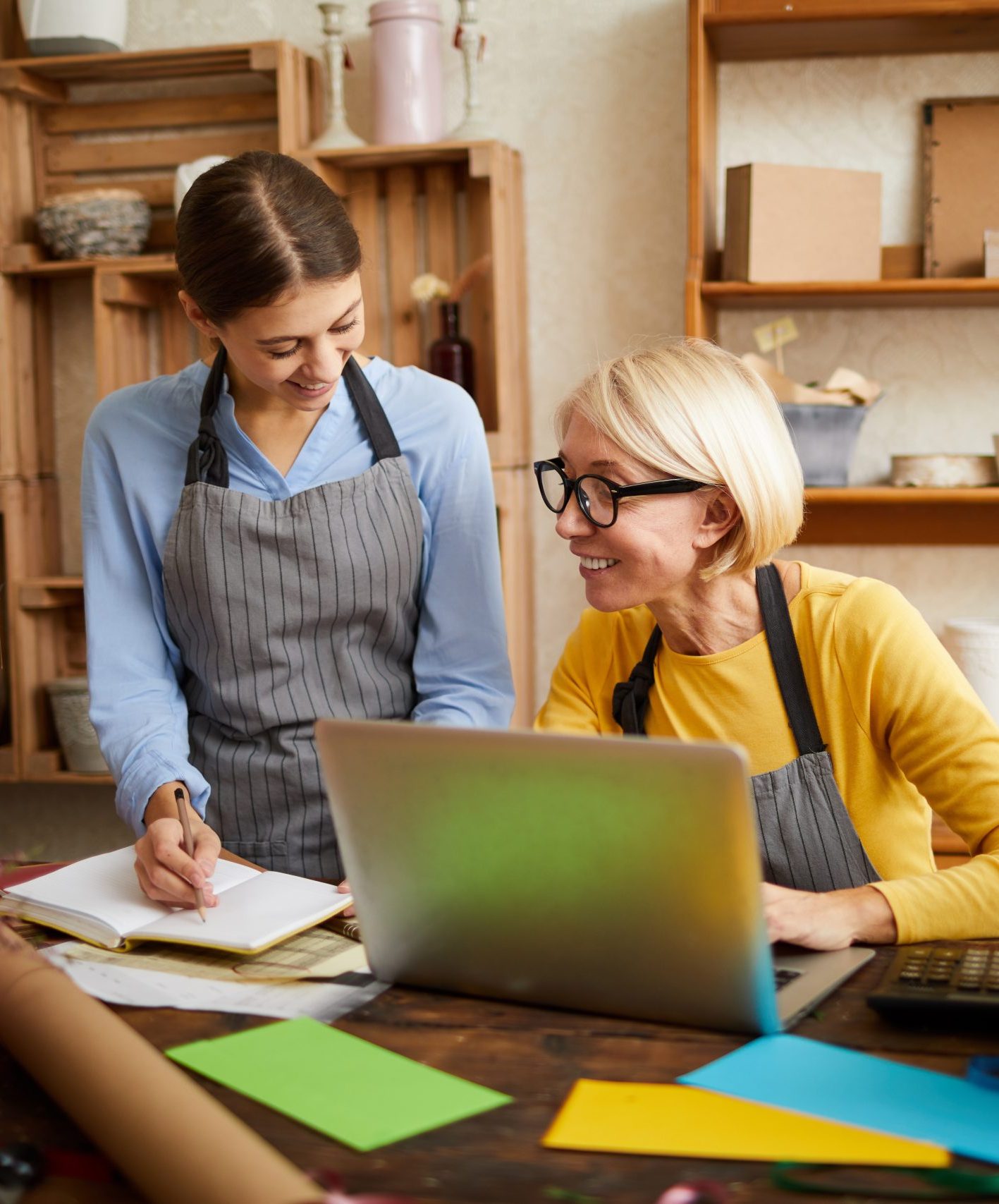Portrait of two businesswomen using laptop while managing shop, copy space